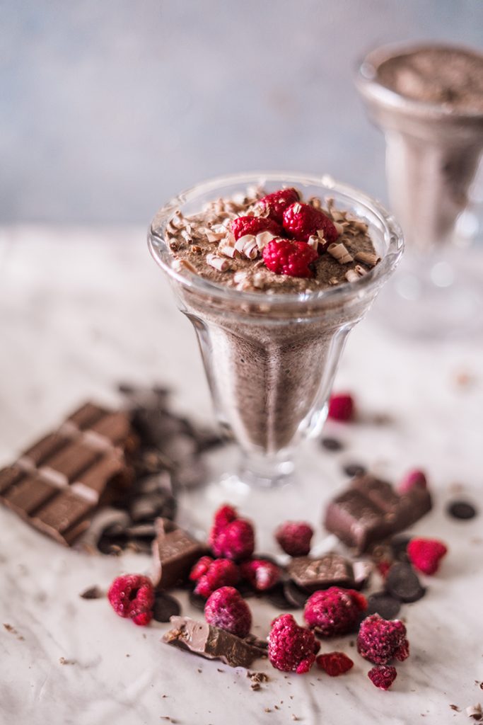 full view of vegan chocolate mousse with raspberries and chocolate bars