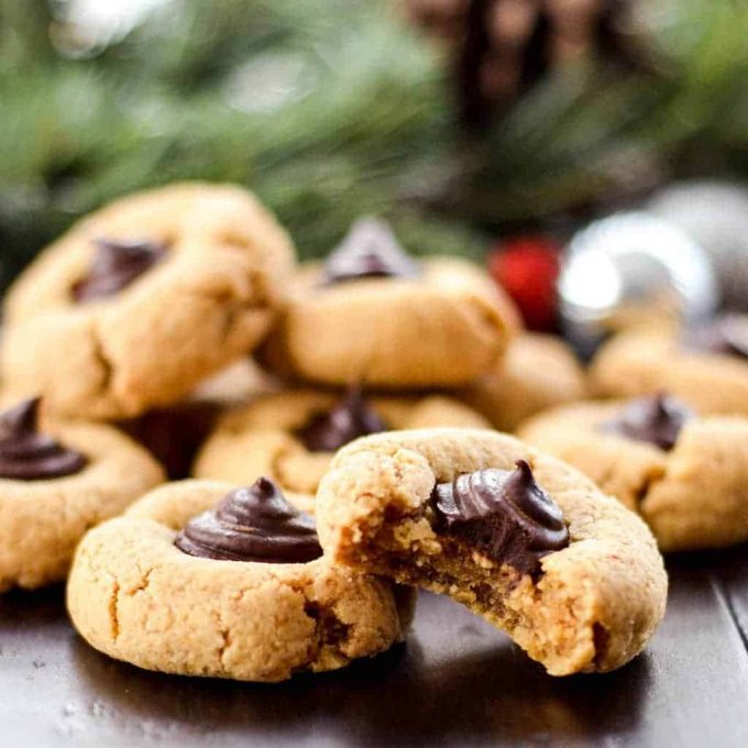 Pile of round Vegan Almond Butter Blossom Cookies with chocolate in the middle.