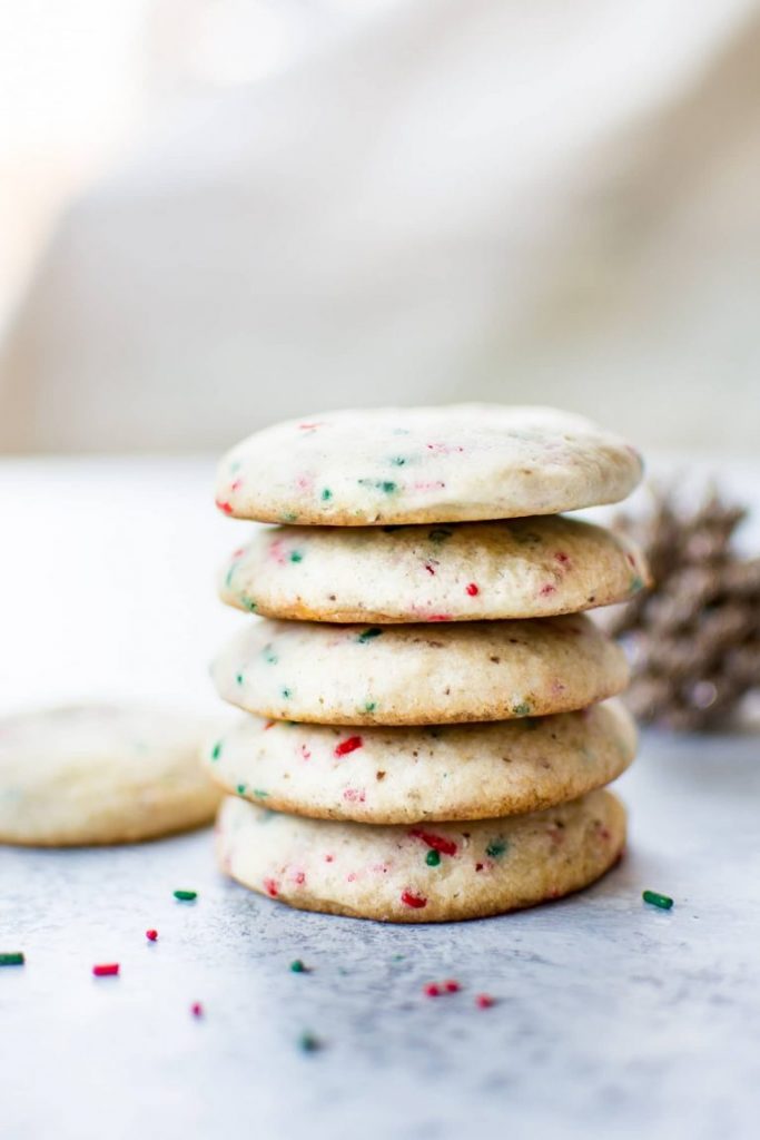 Stack of vegan sugar cookies with red and green sprinkles mixed in.