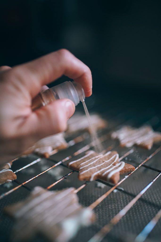 spraying flavor on salted caramel cookies with white chocolate drizzle