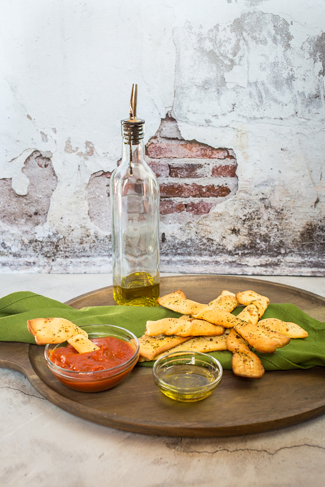 vegan breadsticks on plate with oil and dipping sauces