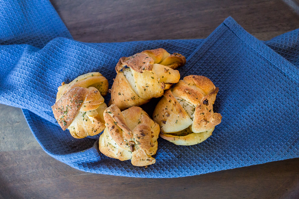 large vegan garlic knots laying on a blue towel to showcase size