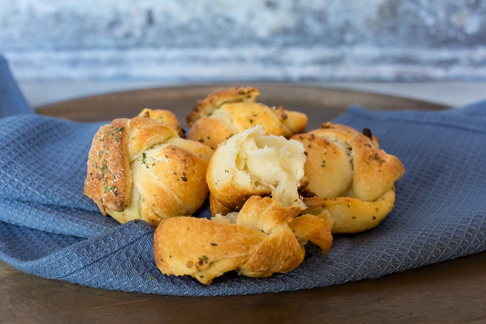 close up of vegan garlic knots that are warm on a blue towel