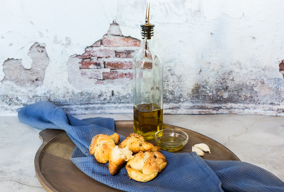 olive oil with vegan garlic knots on a plate