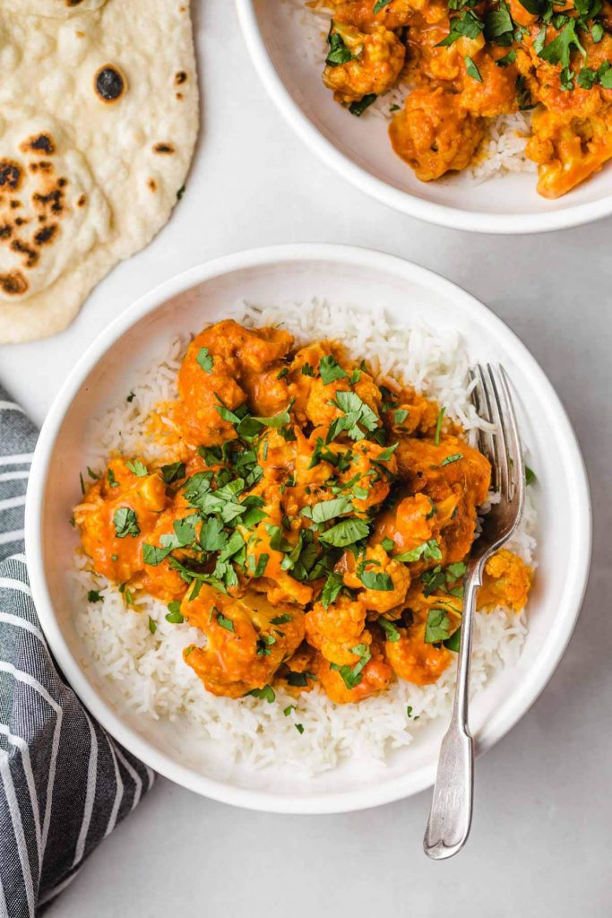 Photo of vegan butter cauliflower "chicken" being served in white bowls.