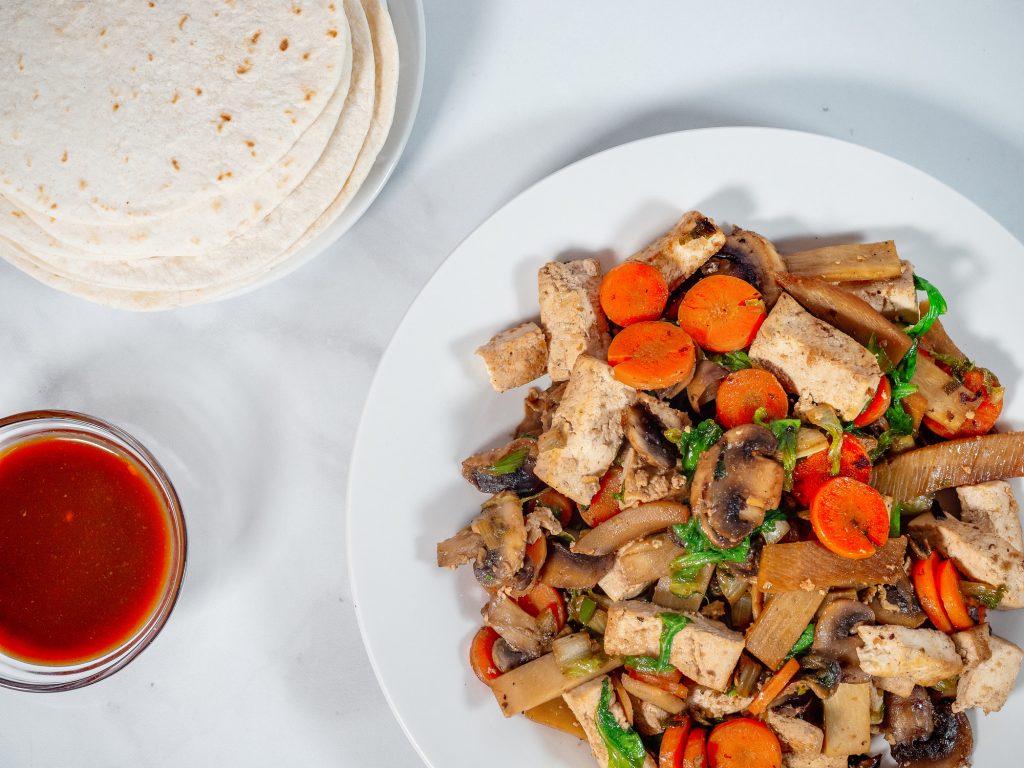 moo shu vegetables with chinese pancakes and hoisin sauce on white plate