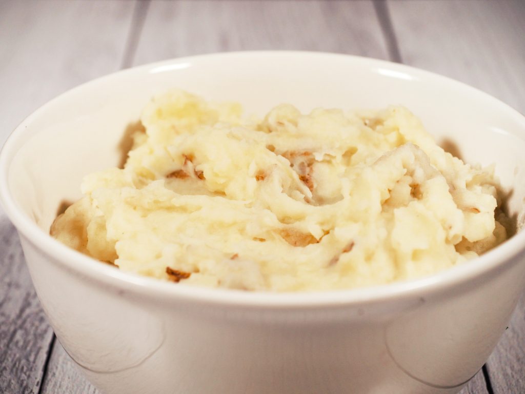 close up photo of  dairy free mashed potatoes in a white bowl on a white counter