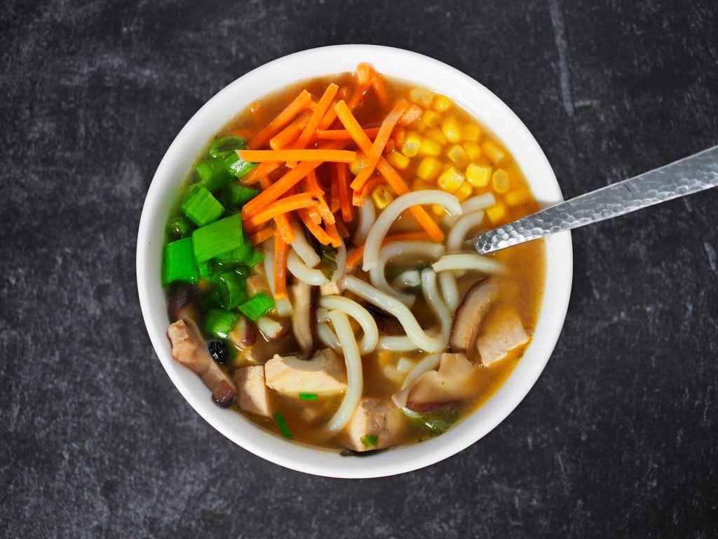 udon noodles in vegan broth on black countertop