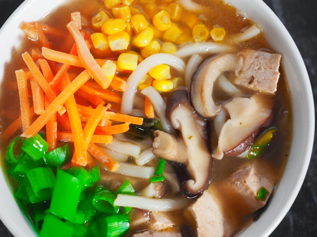 close up of vegan udon noodle bowl with lots of colorful veggies