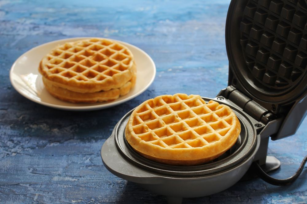 circular waffle iron on blue counter