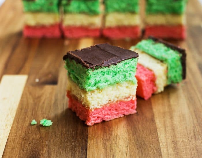 Photo of Italian Rainbow cookies which are colorful and resemble the Italian flag when cut into pieces. A real show stopper among the vegan Italian recipes.