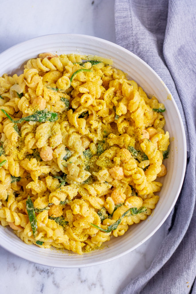 Photo of a large bowl serving chickpea Florentine pasta. One of the creamiest among the vegan Italian recipes.  