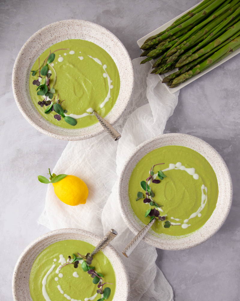 Photo of three bowls serving vegan cream of asparagus soup, one of the most creamy among the vegan soup recipes.