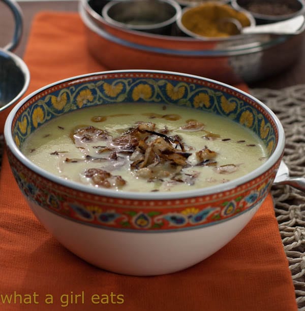 Photo of a small bowl with a colorfully decorated rim serving curried cauliflower soup.