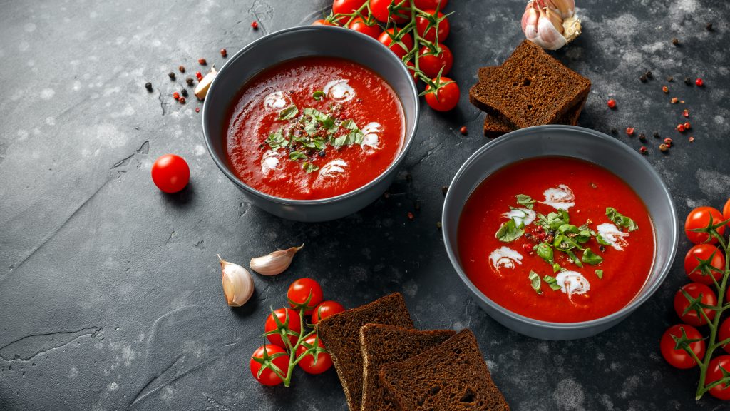 Photo of two bowl of creamy tomato basil soup. 