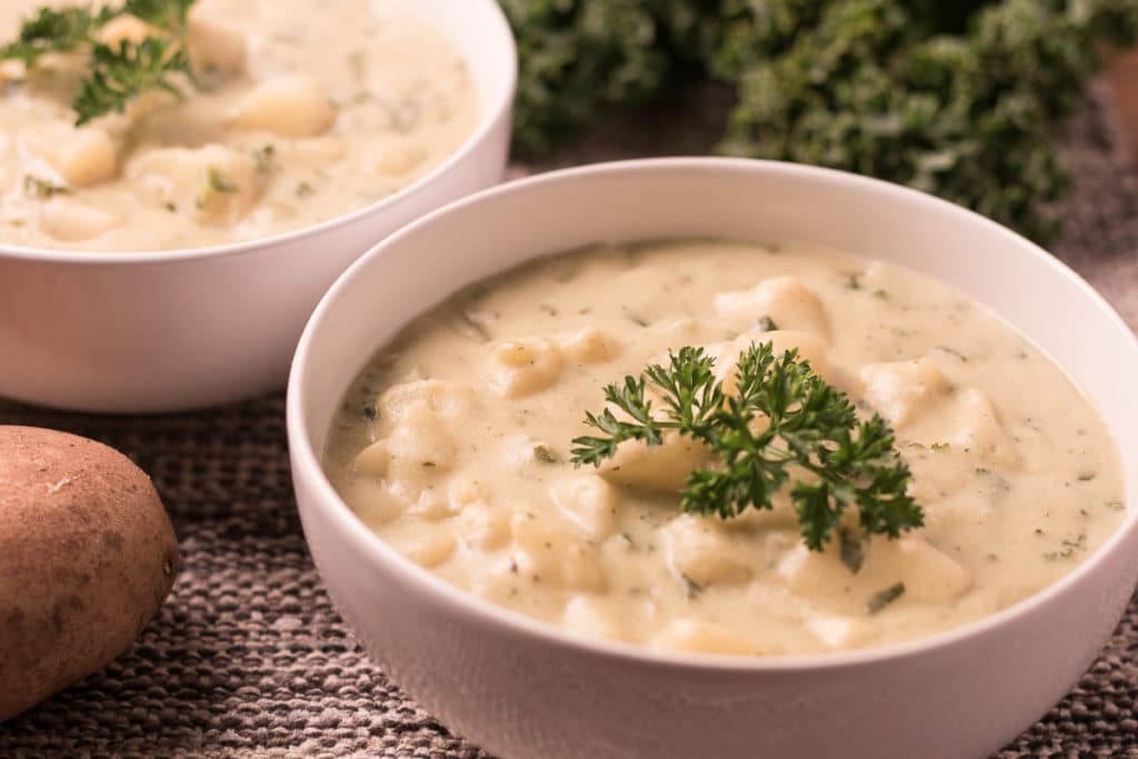 Photo of potato kale being served in a small round white bowl.