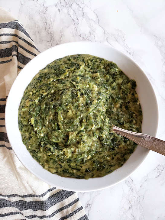 Photo of a small round white bowl serving creamed spinach.