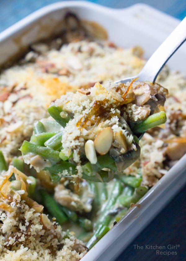 Photo of vegan green bean casserole being scooped up with a large serving spoon. 