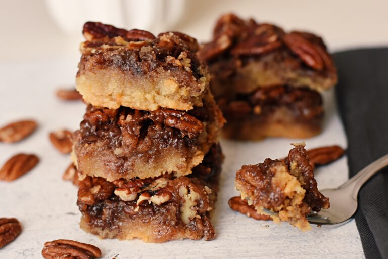 Photo of several pecan pie bars stacked on top of each other. 