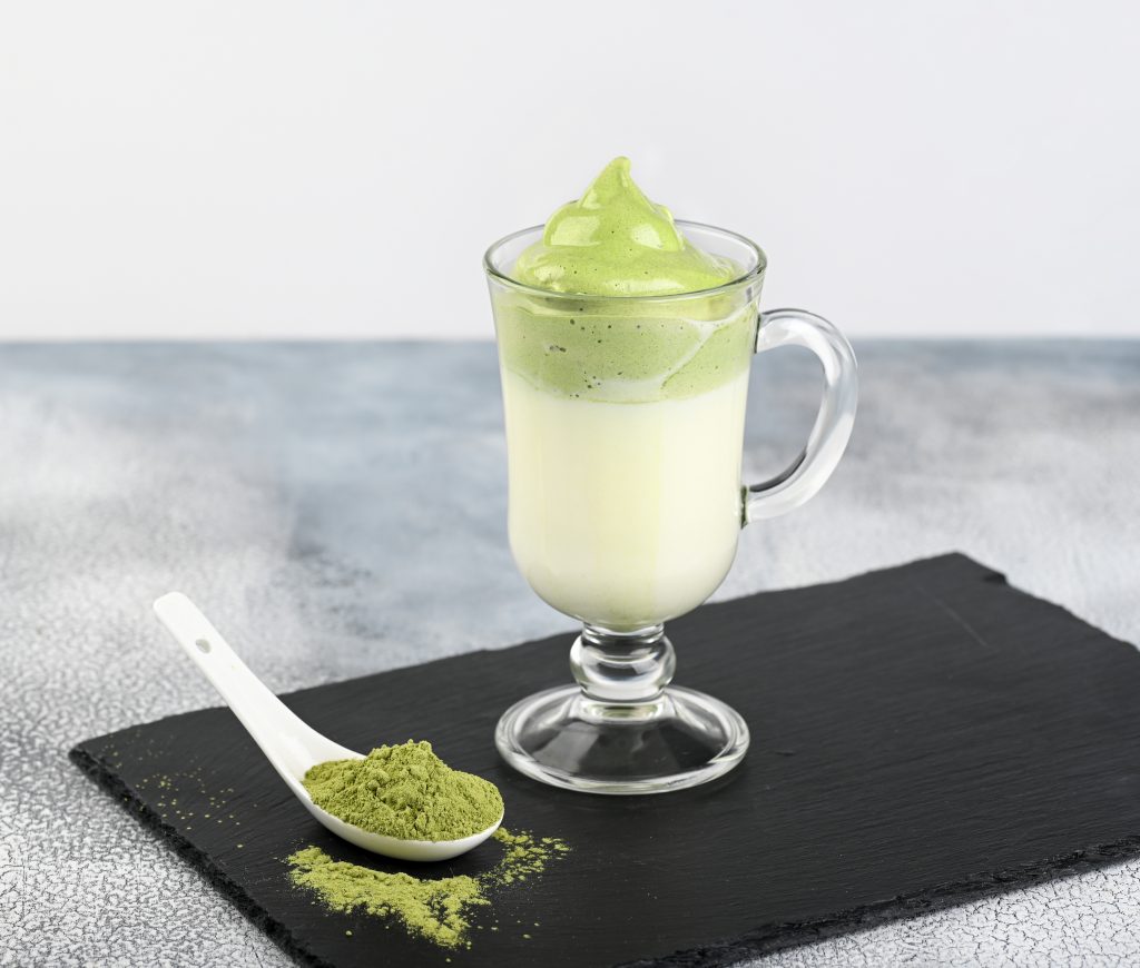 Premium Photo  Iced green tea matcha dalgona in two glasses with a straw  and a bowl of matcha powder for cooking on a wooden tray white background  space for text