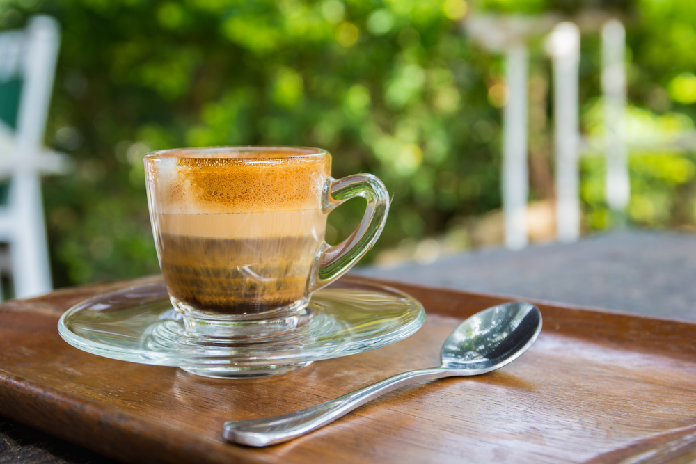 An espresso Macchiato on a table with a spoom