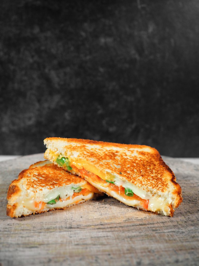 far away image of grilled cheese with tomato on a plate