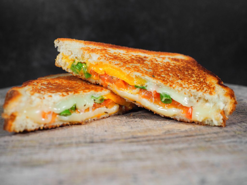 grilled cheese with tomato on black background