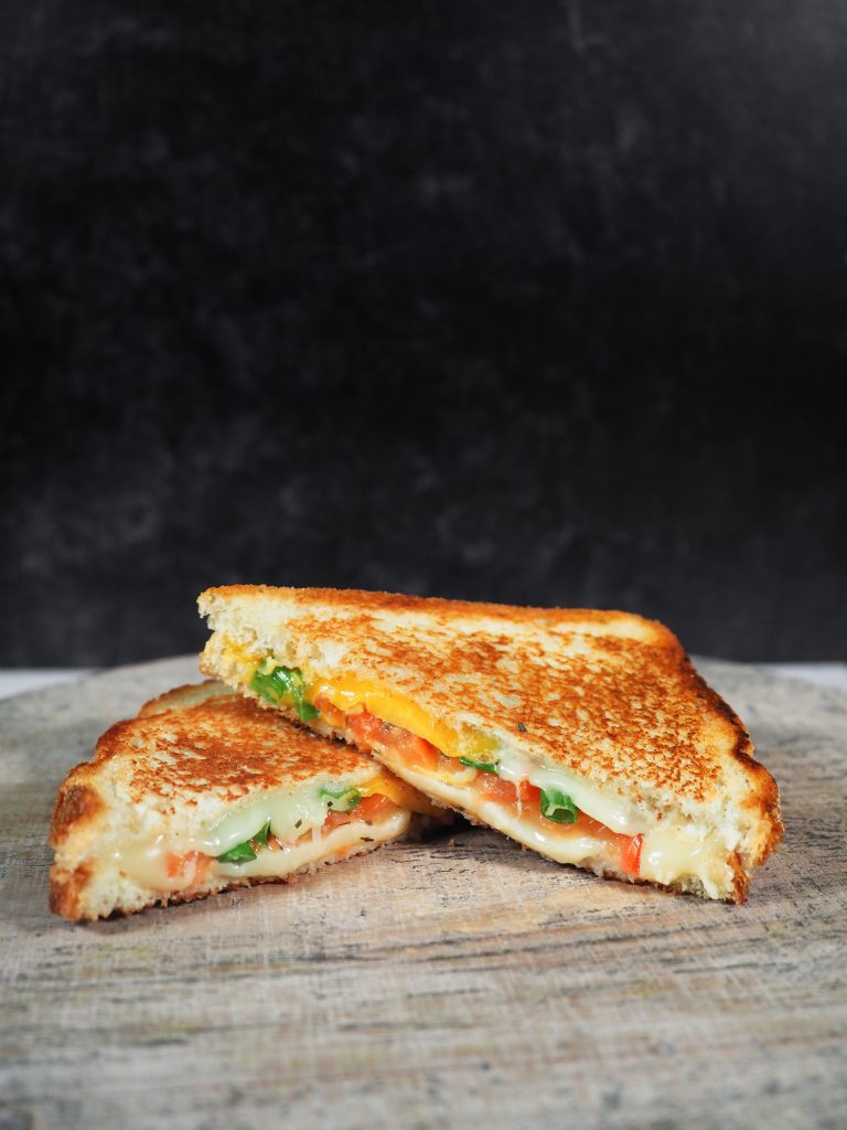 wide photo of grilled cheese with confetti veggies and tomato
