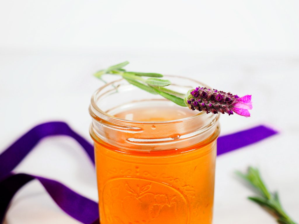 lavender simple syrup in jar with lavender flower