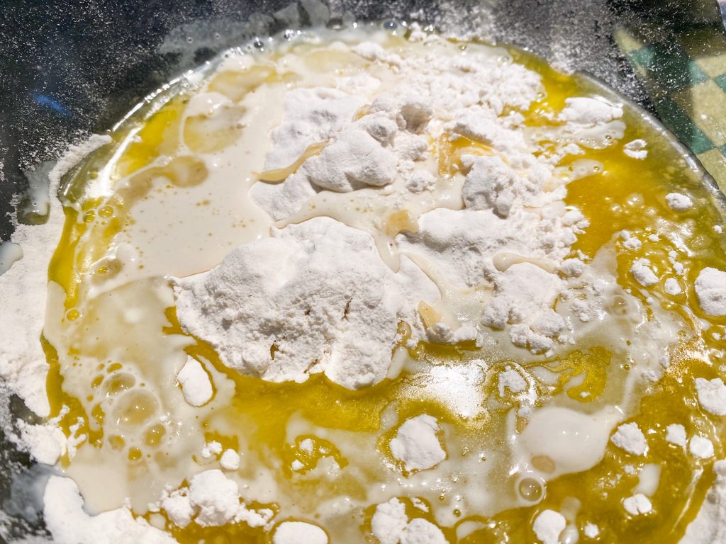close up of unmixed ingredients in bowl to make pie crust with oil and milk.