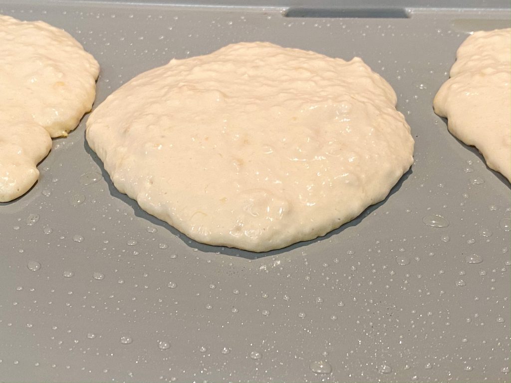 vegan blueberry pancakes cooking on heated griddle