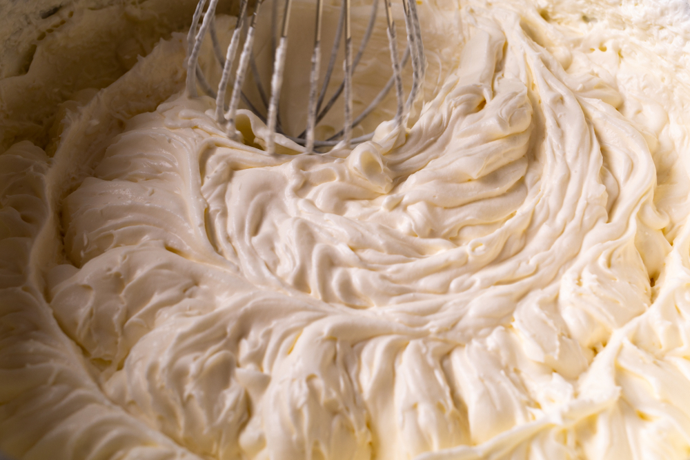 close up of a whisk with vegan buttercream frosting