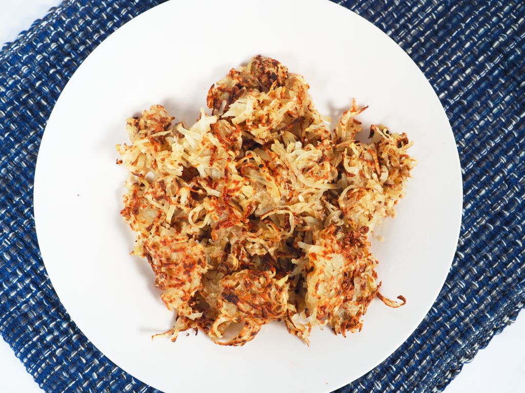 vegan hash browns on plate with blue placemat