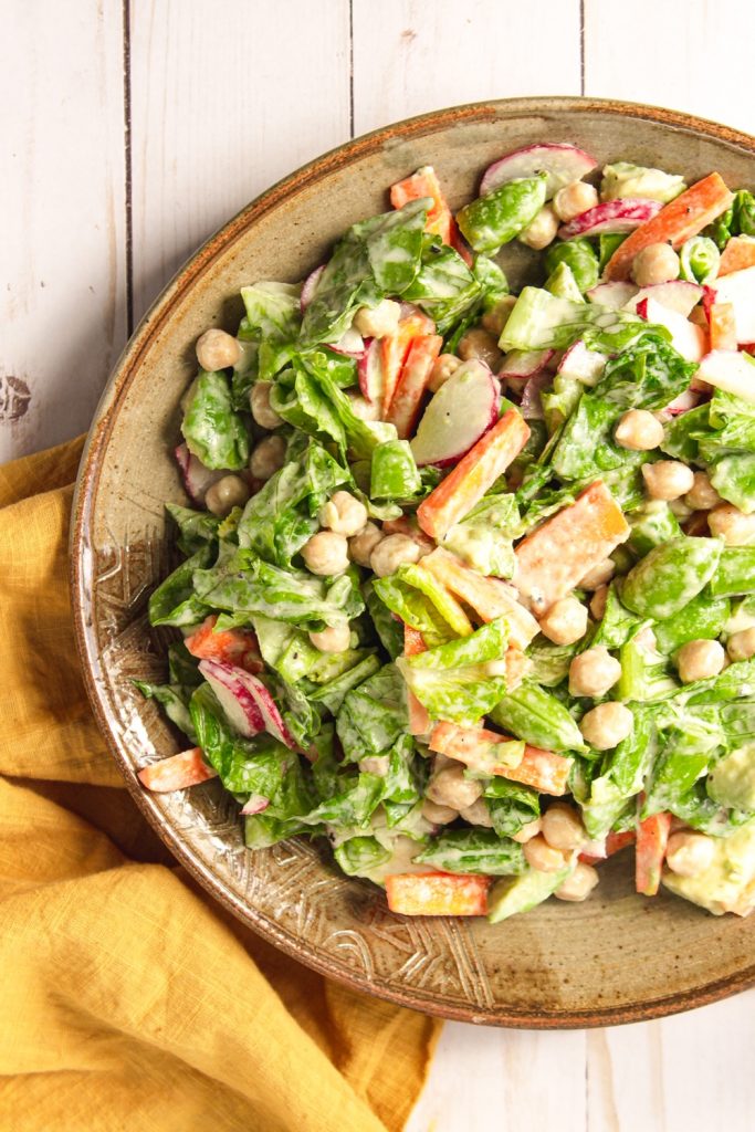 Photo of a large round plate serving an easy vegan chopped salad which is perfect for a vegan Mother's Day brunch. 