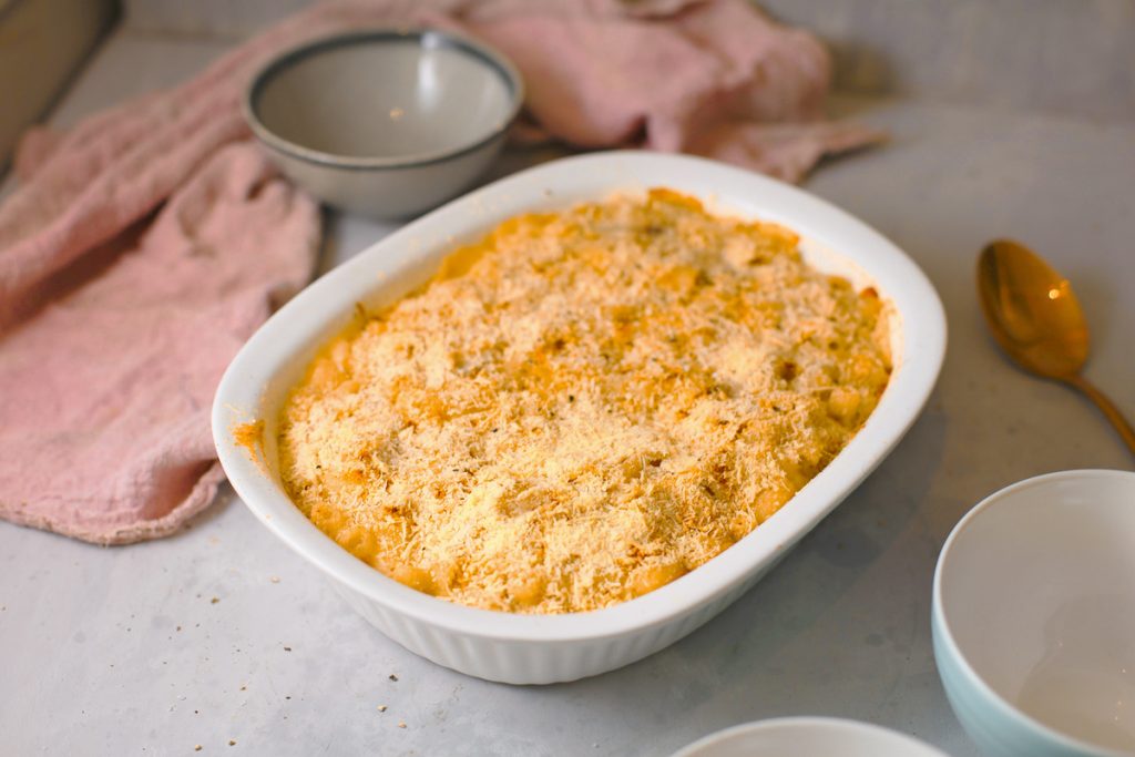 Photo of a large casserole dish serving creamy baked vegan mac and cheese. One of the creamiest and most comforting among the vegan Thanksgiving recipes. 