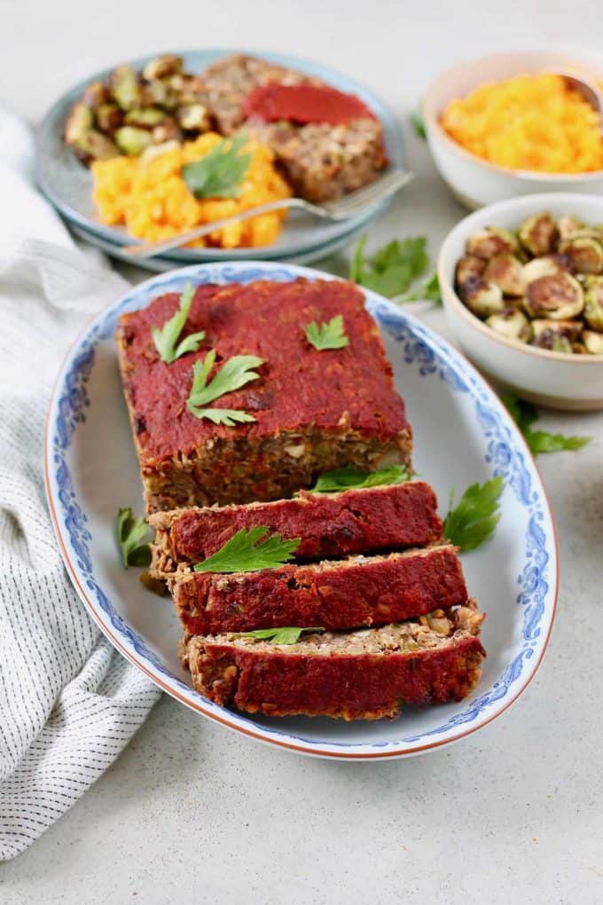 Photo of a sliced vegan lentil loaf being served on a blue and white plate. 
