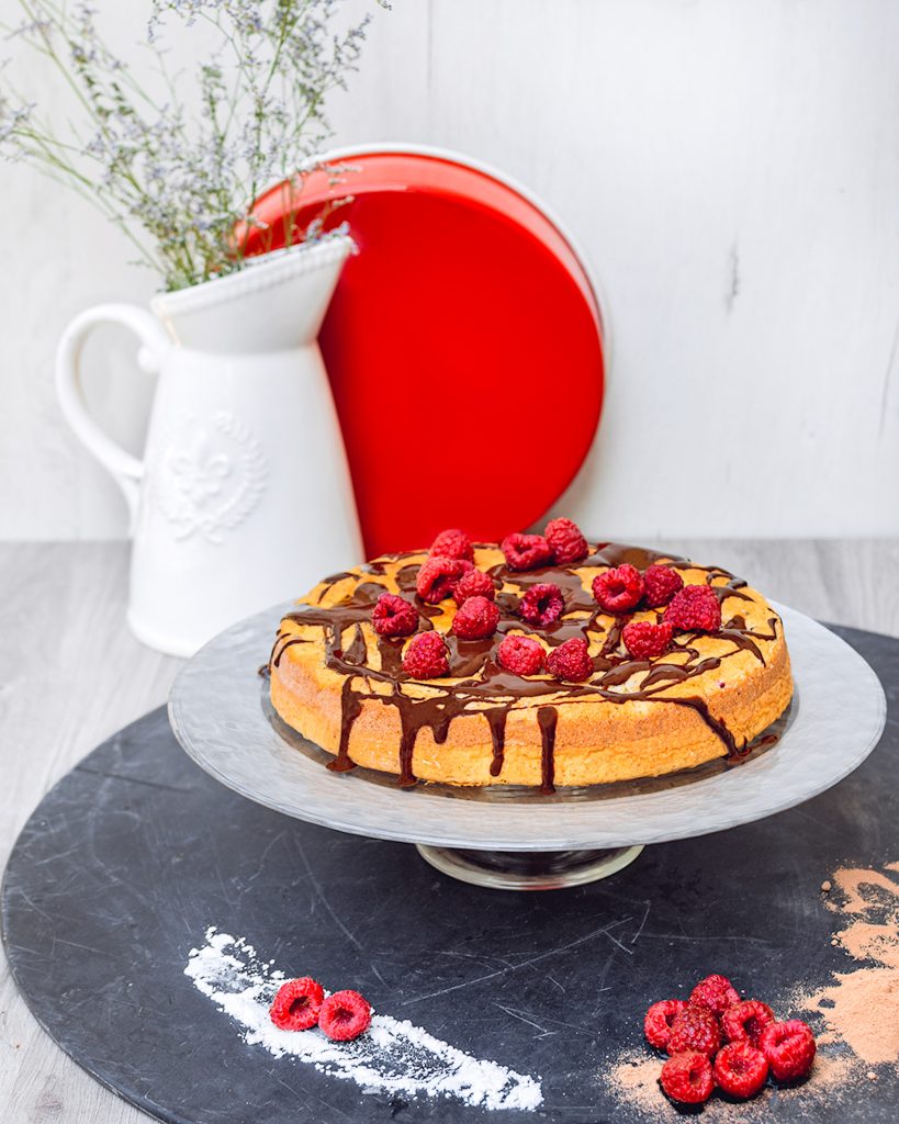 chocolate raspberry cake on cake plate and dark background