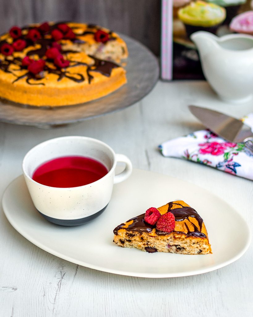 slice of chocolate and raspberry cake with tea