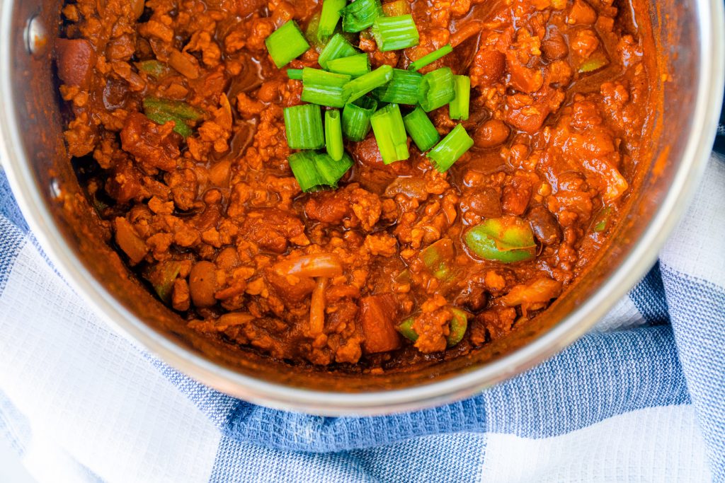 top down view of easy vegan chili in pot with green onions