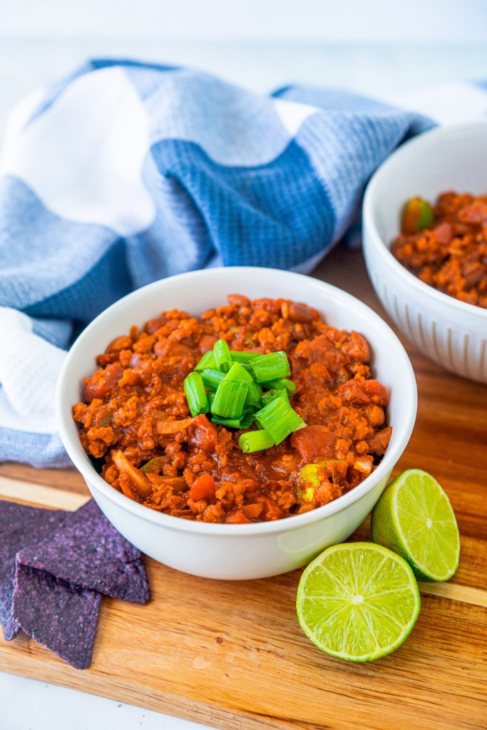 easy vegan chili recipe in bowl with limes and tortilla chips