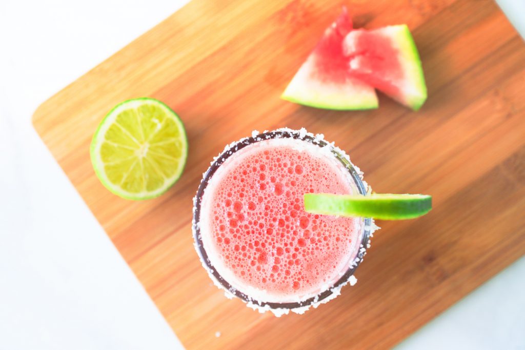 photo of a frozen watermelon margarita on a cutting board with lime and watermelon