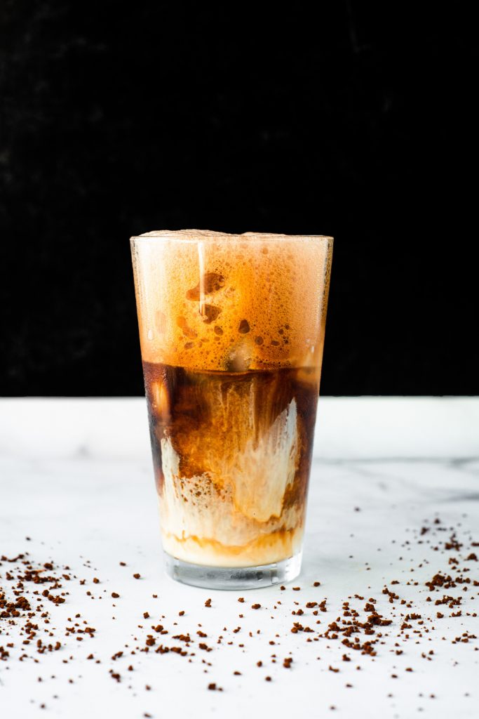 photo of a frothy greek frappe in a cup on a black background