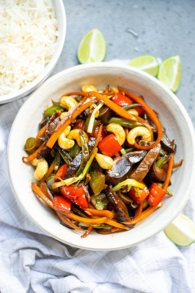 kung pao vegetables in a bowl with limes