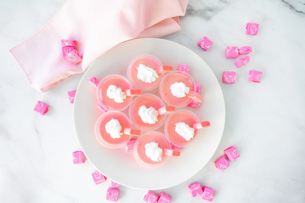 flat lay of pink starburst jello shots with pink napkin