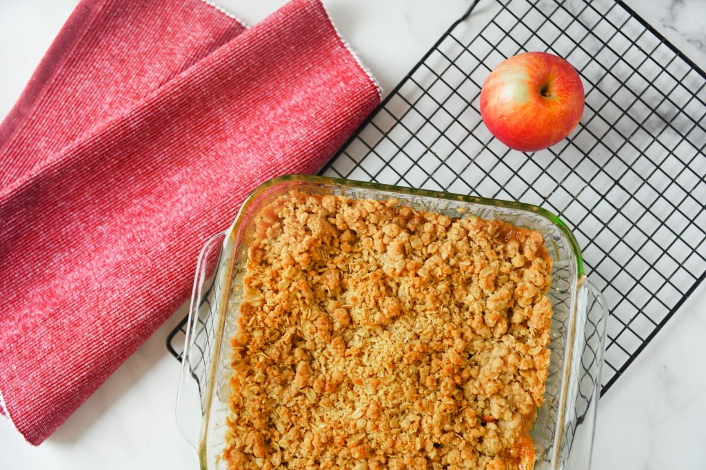 vegan apple crisp from above on cooling tray with apple and red place mat
