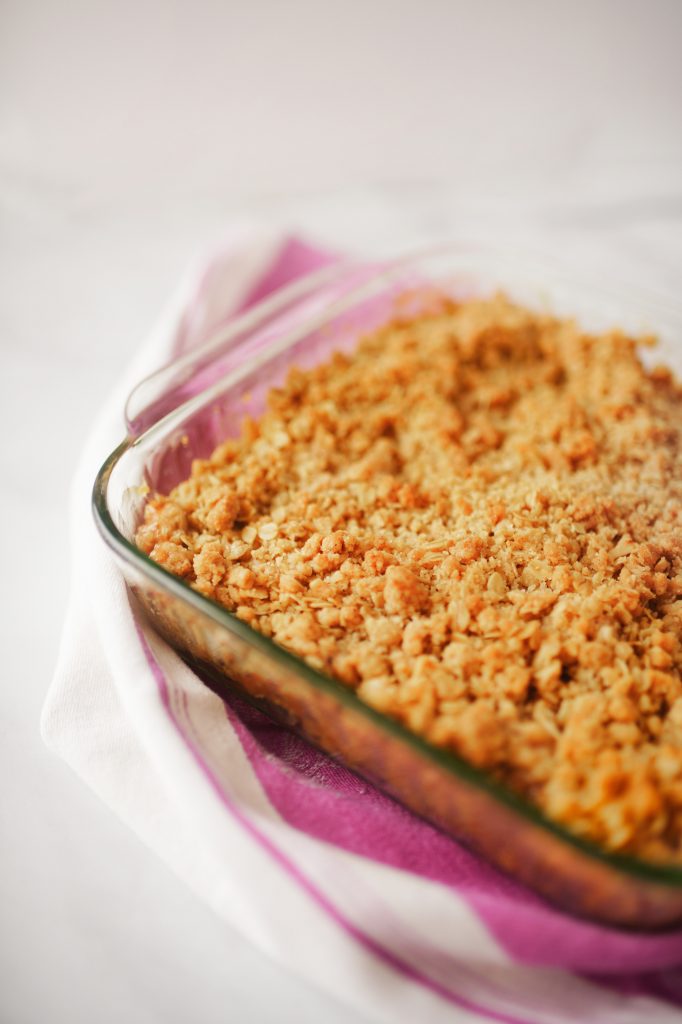 close up of brown apple crumble on purple dish towel