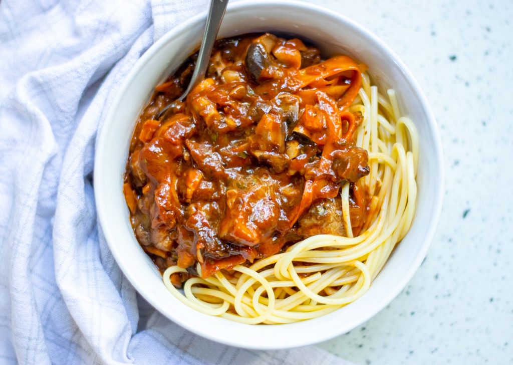 close up of mushroom vegan bolognese sauce with carrots over pasta