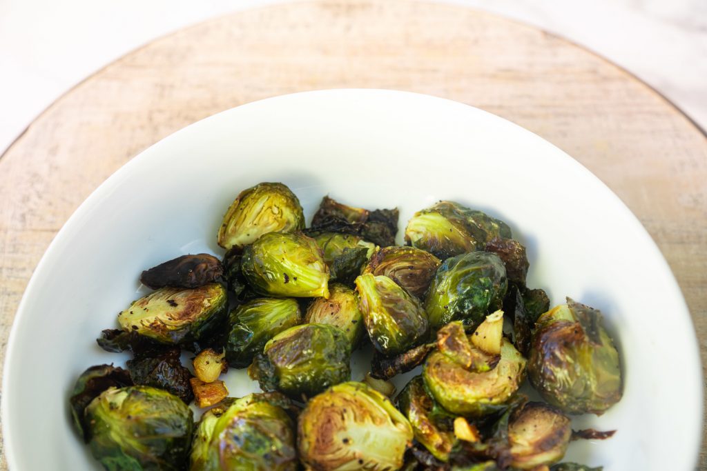 vegan brussels sprouts over a brown serving tray