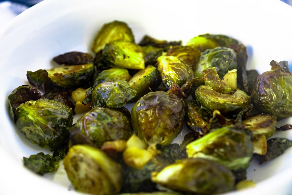 Photo of a white bowl serving Vegan Garlic Brussel Sprouts