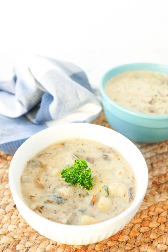vertical image showing 2 bowls of vegan clam chowder soup